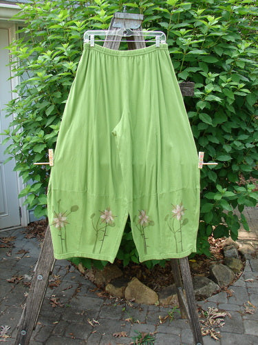 Barclay 4 Square Pant Floral Reach Spearmint Size 0 draped on a wooden ladder, showcasing its unique 3D diamond cut from the knee down and full elastic waistband.