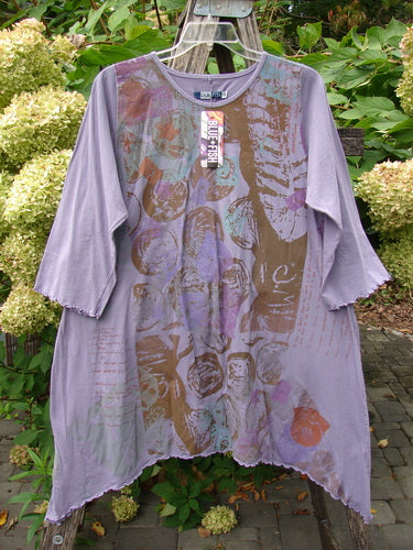 Barclay NWT Three Quarter Sleeve Color Wheel Tunic Many Moons Violet Size 0 features a loose fit, abstract print, asymmetrical hem, and lettuce-edged sleeves, displayed on a wooden rack outdoors.