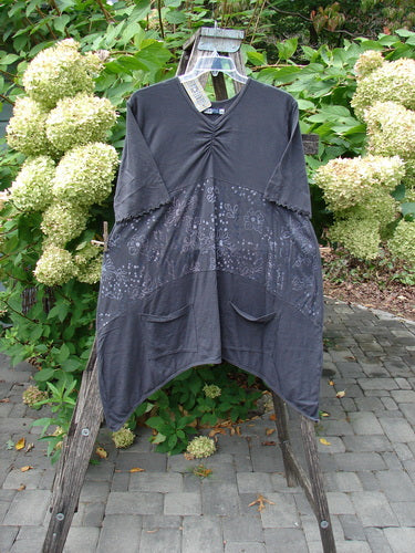 Barclay NWT Perfect Day Pocket Tunic Dress Script Daisy Black Sand Size 0, showcasing a loose charcoal-gray design with oversized front pockets, a shallow V-neckline, and a subtle all-over print, hanging outdoors.
