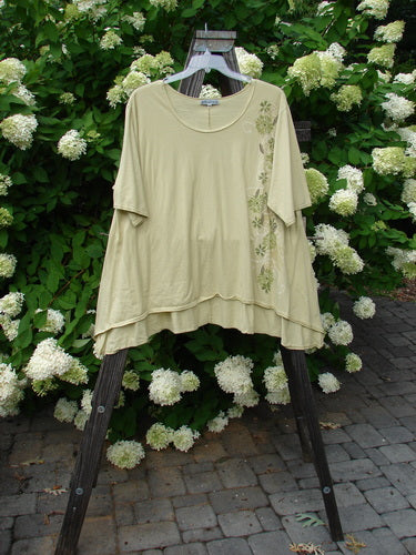 Image alt text: Barclay High Low Top in Dandelion, a swingy shirt with a floral design on a rack.