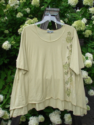 Image alt text: Barclay High Low Top Dandelion Trail Dawn Size 2: A swingy shirt on a wooden stand, featuring a deeper rounded neckline and varying upward front hemline. Made from organic cotton.