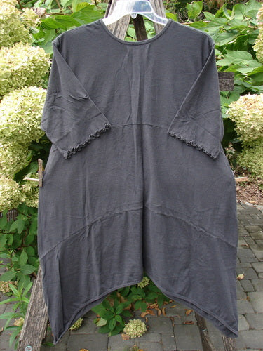 Barclay NWT Perfect Day Pocket Tunic Dress Script Daisy Black Sand Size 0, featuring a loose fit, round neckline with elastic gather, asymmetrical hem, and oversized pockets, displayed against green foliage.