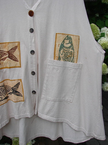 1992 Patched Triangle Vest Vintage Duel Fish Crème OSFA: A white shirt with fish designs and patches, featuring a varying hemline, oversized drop pocket, and flared hemline.