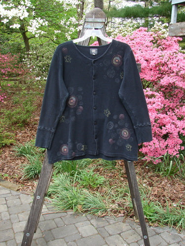 Vintage Blue Fish Clothing 2000 Thermal Lu Top Pinwheel Black Size 2. Long-sleeved black shirt with floral accents, ribbed cuffs, and rubberized buttons. Light, stretchy fabric in perfect condition. Reflects BlueFishFinder's creative freedom ethos.
