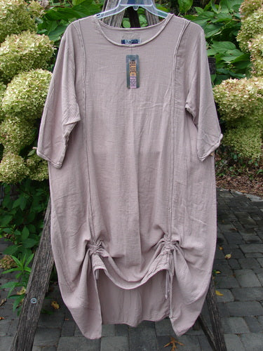 Barclay NWT Textured Batiste Linen Haystack Dress Unpainted Oriel Size 0, featuring elbow-length sleeves, round neckline, and adjustable hem drawstrings, hanging outdoors on a clear hanger.