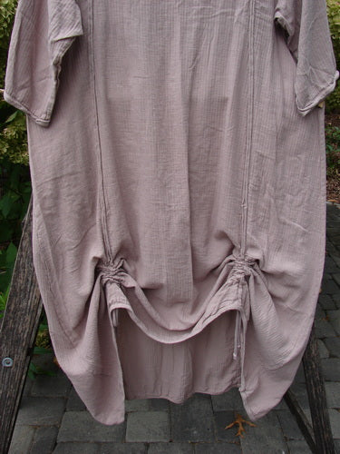Barclay NWT Textured Batiste Linen Haystack Dress Unpainted Oriel Size 0 displayed outdoors, featuring ruched hem with drawstrings, three-quarter sleeves, and vertical rolled seams, epitomizing Bluefishfinder.com's unique vintage charm.