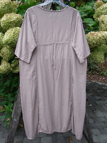 Barclay NWT Textured Batiste Linen Haystack Dress Unpainted Oriel Size 0, featuring a crinkled-gauze fabric, elbow-length sleeves, empire waist drawstring, and side slits, hanging outdoors.