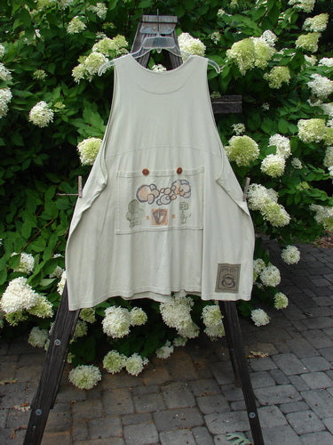 Image alt text: A white apron with a floral design on a wooden stand, part of the 1994 Fishing Vest Magic Garden Aloe OSFA collection.