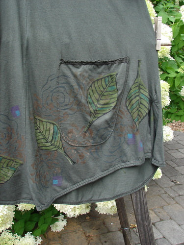 Barclay Double Pocket Lace Twinkle Top in Deep Forest, Size 2. A green shirt with leaves painted on it. Features lace-topped pockets and a banded rounded neckline.