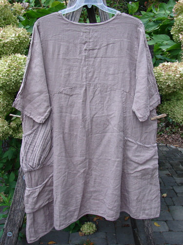 Barclay NWT Linen Calotype Stack Pocket Dress Grow Garden Oriel Size 0, featuring a round neckline, three-quarter sleeves, and oversized pockets, showcased on a wooden frame.