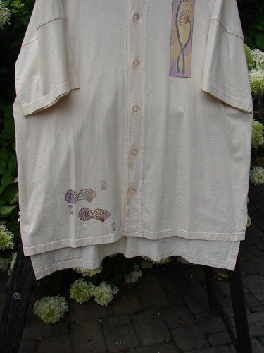 Image: A white shirt with a picture of shells on it.

Alt Text: 1997 Island Beach Jacket Sea Sprig Powder OSFA, featuring a white shirt with a shell design, part of the Vintage Blue Fish Clothing Collection.