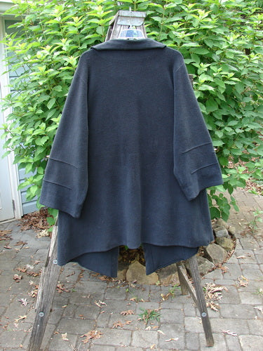 Barclay Celtic Moss Asymmetrical Collar Coat Unpainted Black Size 0 displayed on a wooden stand, showcasing its unique collar, three-button closure, and varied hemline, embodying BlueFishFinder's creative vintage style.