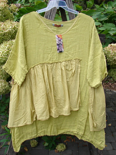 Barclay NWT Gauze Batiste Petal Urchin Flounce Dress Unpainted Citron Size 1, featuring a layered gathered front, swing-style drape, and clear Blue Fish tag displayed against a garden backdrop.