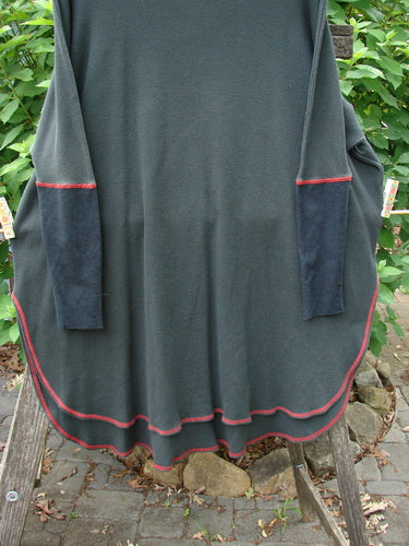 Barclay Thermal Contrast Revival Top Unpainted Black OSFA, showcasing ribbed sleeves and a rounded neckline, hanging elegantly on a rack, highlighting its unique A-line shape and side vents.