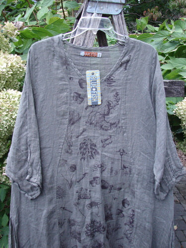 Barclay NWT Linen High Vent Venetian Dress Farm Dark Caper Size 1, featuring 3/4-length sleeves, darker natural motifs, and an oval neckline, displayed on a hanger against green foliage.