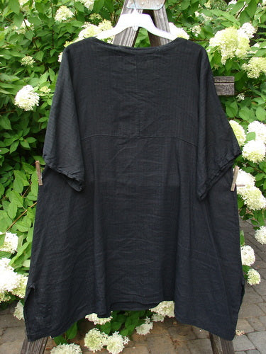 Barclay Linen Viscose Vented Urchin Dress in Stripe Black, size 2, on a clothes line. Three-quarter length sleeves, V-shaped neckline, and empire waist seam. Lovely fluttering fan theme.