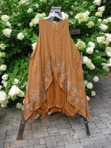 A Barclay Linen Open Front Drawcord Hem Jumper in Squash, featuring a brown dress with purple floral design on a rack.