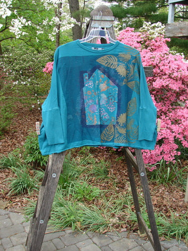 Barclay Crop Rib Sleeve Top displayed on wooden ladder, embodying BlueFishFinder's vintage charm. Organic cotton, dolman sleeves, crop length, ribbed accents, and a boxy silhouette. Perfect for expressing individuality.