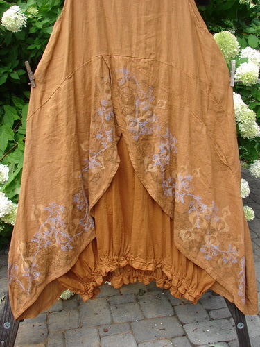 Barclay Linen Open Front Drawcord Hem Jumper Garden Squash Size 2: A brown skirt with a floral design, featuring an interesting layered cross over front apron and a batiste under skirt layer.