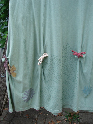 Barclay Constellation Jumper Garden Folly Aloe Size 1 features a deeply scooped neckline, dimensional hemline with pointed accents, and vertical panels, showcasing a garden-themed paint pattern.