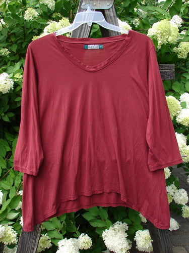 A maroon Barclay Tissue Raglan V Neck Layering Top, size 2, with a soft V-shaped neckline and 3/4 length sleeves. The top has a slight hourglass shape and a varying hemline, resembling a tee with more curve.