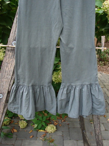 Barclay NWT Poplin Bottom Pantaloon Unpainted Chimera Size 0 displayed on a wooden rack outdoors, featuring loose-fit slate-gray fabric with gathered ruffle cuffs at the ankles.