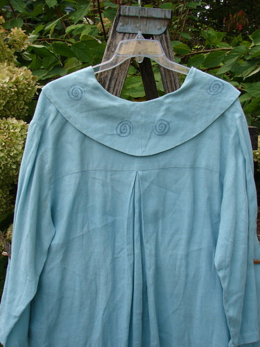 1999 Linen Breeze Jacket Tea & Cherries Spring OSFA, featuring a wide yoke with spiral embroidery, single button closure, painted sailor collar, drop front pockets, and a flowing silhouette, hangs on a clear hanger.