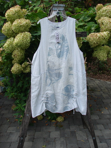 Barclay NWT Linen Image Pinafore Pocket Overpiece Floral Burst Dew Size 0, displayed on a hanger, featuring a rounded neckline, deeper arm openings, dual drop pockets, and double drawcord sides.