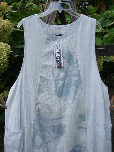 Barclay NWT Linen Image Pinafore Pocket Overpiece Floral Burst Dew Size 0 features a sleeveless, light-blue linen tunic with round neckline, dual side pockets, and subtle print, hanging against greenery.