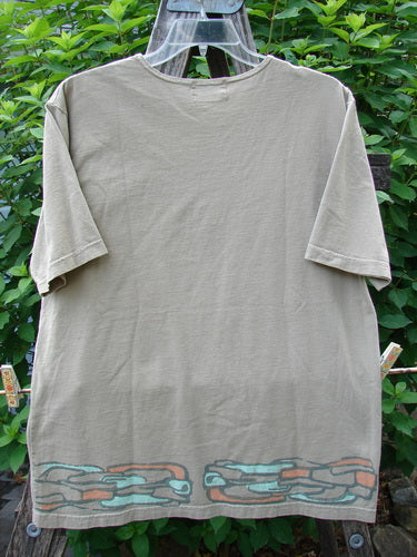 Barclay Short Sleeved Tee Stone Path Border Wheat Size 1 displayed on a clothes rack, featuring a rounded thin neckline, short sleeves, and a straight wide shape with an artistic border theme.