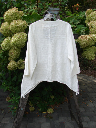 Barclay NWT Linen Basque Cardigan in Unpainted White Size 0, featuring a deep V-neck, dippy sides, vented hemline, long wide sleeves, and oversized shell buttons, displayed on a hanger.