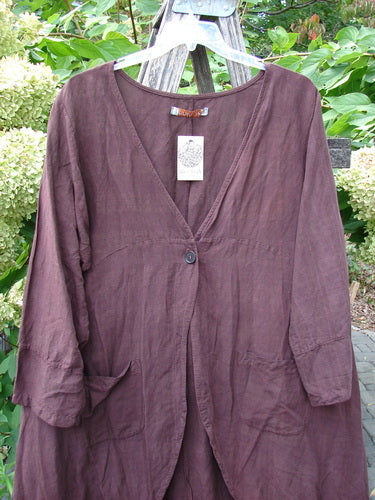 Barclay NWT Linen Geoides Pocket Duster in Armagnac Red Plum, featuring a V-neck, single button closure, patch pockets, and full-length sleeves, hanging on a hanger outdoors.