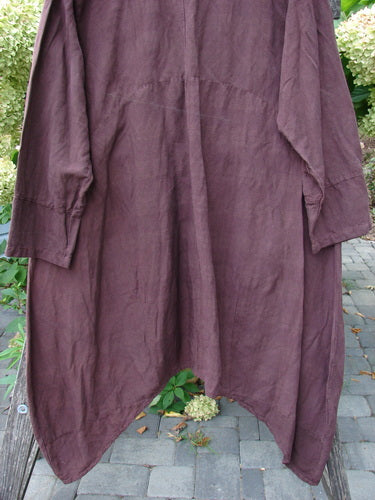 Barclay NWT Linen Geoides Pocket Duster in Armagnac Red Plum Size 1, a loose-fitting kaftan with asymmetrical hems, displayed over a bench on an outdoor patio.