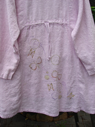 Barclay Linen Shell Button Drawcord Cardigan Butterfly Orchid Size 0 featuring a subtly rounded neckline, shell buttons, and a butterfly garden theme with a super drawcord backline, highlighting its flowy A-line shape.