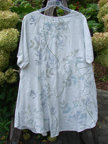 Barclay NWT Linen Contrast Tie Pocket Cardigan Field Twig Dew Size 0 on a hanger, showcasing its botanical pattern with delicate leaves and flowers against a garden backdrop.