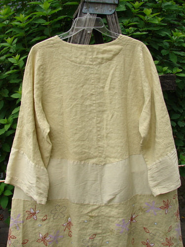 Barclay Linen Wonderland Sectional Banded Cardigan Daisy Chain Celery Size 1 featuring a rounded neckline, belled sleeves, pearly buttons, and whimsical daisy chain design with alternating textured fabric panels.