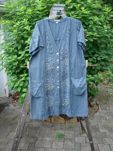 Barclay Linen Double Tie Back Jacket Star Rain Blue Mineral Size 0 displayed on a wooden ladder, showcasing its deep V neckline, A-line sweep, front drop pockets, and short sleeves.