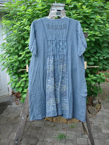 Barclay Linen Double Tie Back Jacket Star Rain Blue Mineral Size 0 hangs on a clothes rack. The jacket features a deep V-neckline, A-line sweep, exterior stitchery, and front drop pockets.