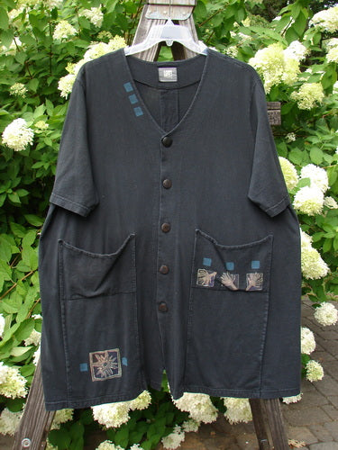 A black Double Decker Pocket Top with oversized pockets stacked on top of each other. Made from organic cotton. Features a pleated back line and a swing. Size 2.