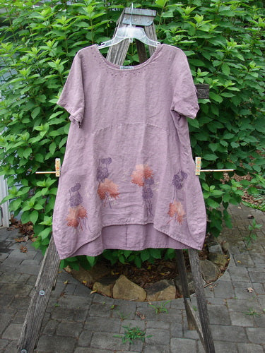 Barclay Linen Urchin Dress Necklace Leaf Dusty Plum Size 0 displayed on a wooden rack, showcasing its unique painted hemline and floral design, embodying Bluefishfinder.com's vintage fashion ethos.