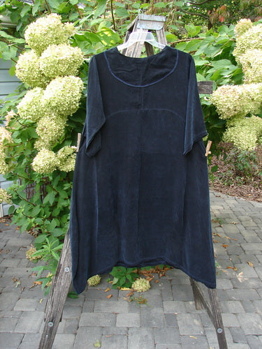 Barclay NWT Cupro Cross Over Urchin Dress elegantly draped on a wooden ladder, showcasing its loose fit and luxurious, velvet-like fabric, perfect for evening wear.