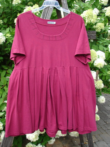 Barclay Boxcar Dress with rear blossom design in cranberry color, size 2. Made from medium weight cotton jersey. Features include squared double paneled neckline, empire waist seam, wide full pleats, and a lower flair. Bust: 50, Waist: 52, Hips: 58, Hem Circumference: 120, Length: 37 inches.