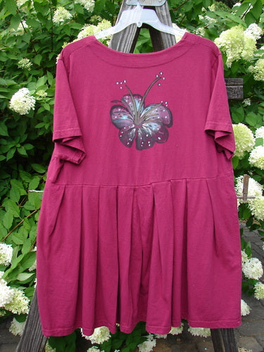 A Barclay Boxcar Dress with a rear blossom theme paint design. Size 2 in cranberry. Made from medium weight cotton jersey. Features include a squared double paneled deeper neckline, empire waist seam, wide full pleats, and a lower flair. Bust 50, waist 52, hips 58, hem circumference 120, length 37 inches.