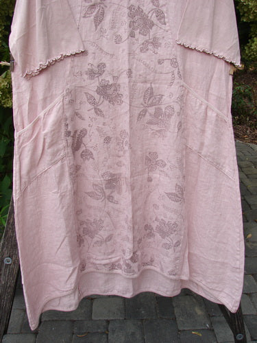 Barclay NWT Linen Le Jardin Cotton Sleeve Pocket Dress Victorian Floral Petal Size 0 displayed outdoors with short ruffled sleeves, two large side pockets, and a below-knee hem, showcasing a botanical print.