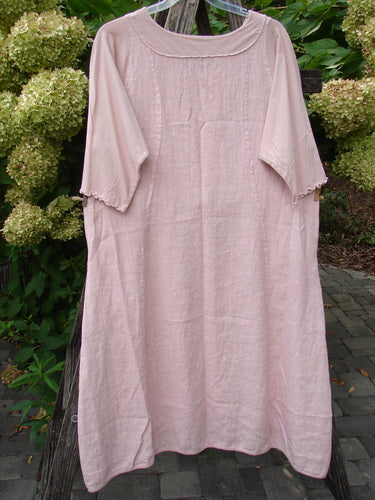 Barclay NWT Linen Le Jardin Cotton Sleeve Pocket Dress Victorian Floral Petal Size 0, displayed on a hanger with elbow-length sleeves and loose fit, set against a garden backdrop with hydrangeas.