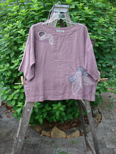 Barclay Linen Lantern Boxy Top Corner Floral Hydrangea Size 0 on display, showcasing its substantial medium-weight linen fabric, boxy shape, drop shoulders, rounded neckline, and distinctive corner floral design.