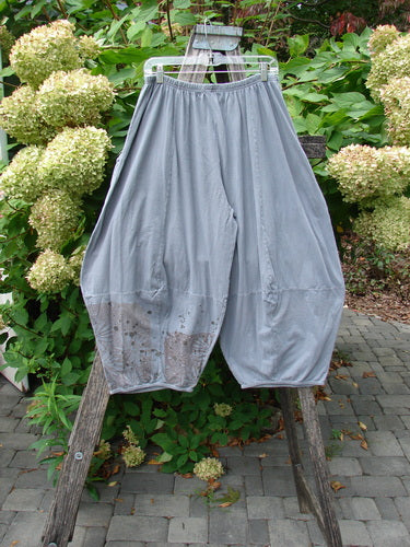 Barclay Crop Two Pocket 4 Square Pant Spin Flower Grey Green Size 0 draped on an outdoor ladder, showcasing loose, gathered legs with faint stains, highlighting its unique, vintage style and artistic design.