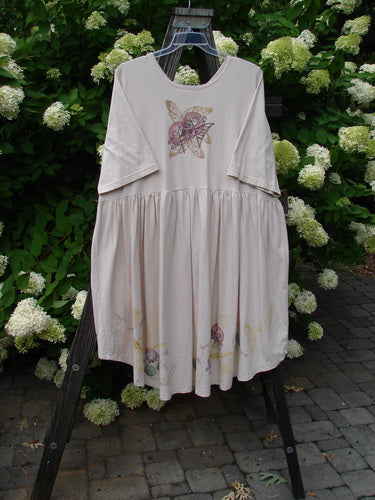 Barclay Flower Garden Cardigan Dress with butterfly design on a rack.