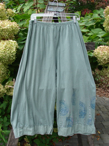 Barclay Flutter Bottom Crop Cargo Pant Medallion Vine Size 0, featuring wide-leg cropped design with unique flutter hem and dual front floppy cargo pockets, displayed hanging outdoors against lush greenery.