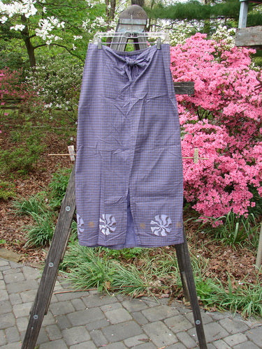 Vintage 1996 Woven Clambake Skirt from Niagara Collection on a wooden ladder. Features a partial front tie waist, elastic back, and front walking vent. Perfect condition, woven organic cotton. Size 2.